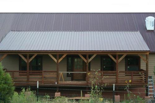 Custom redwood deck accents this barn style home